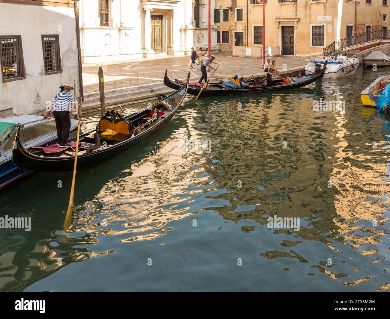 Zwei Gondoliere beginnen ihre Fahrt in Venedig, Italien. Stockfoto