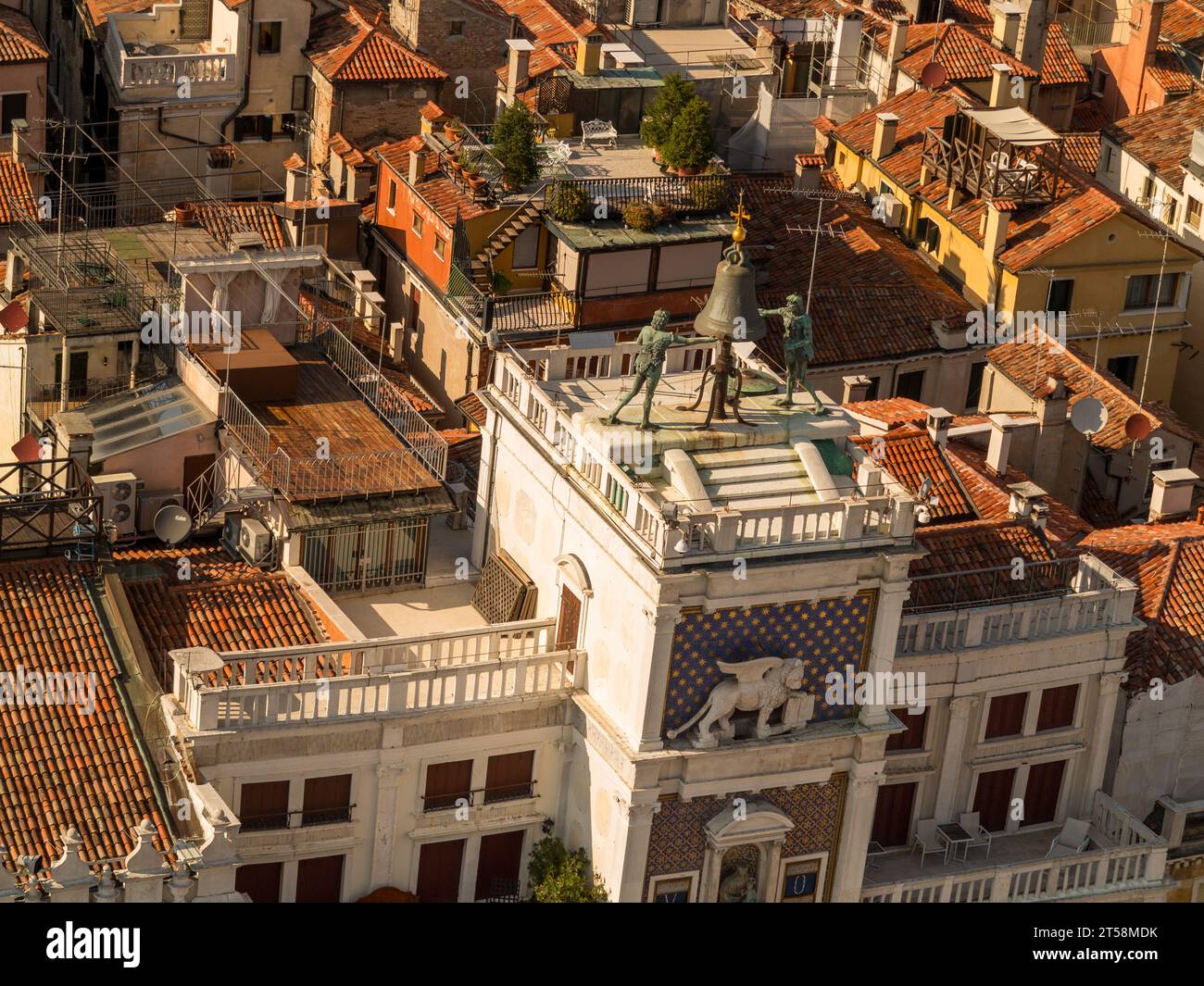 Blick aus der Vogelperspektive auf den Uhrturm von St. Markus, St.. Markusplatz, Venedig, Italien. Wir sehen auch die Dächer der umliegenden Gebäude. Stockfoto