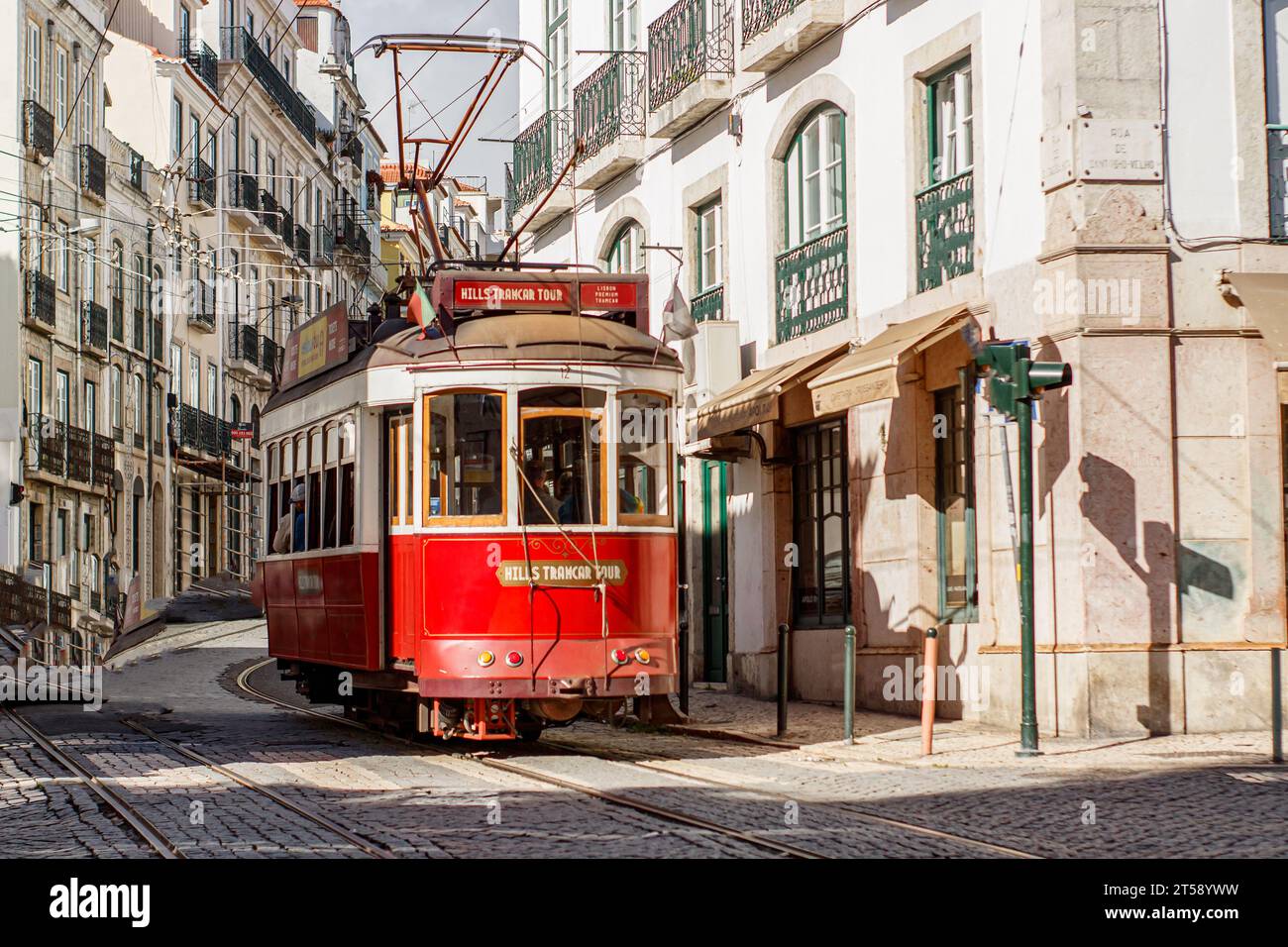 Rote Straßenbahn in Lissabon, die durch die Stadt fährt Stockfoto