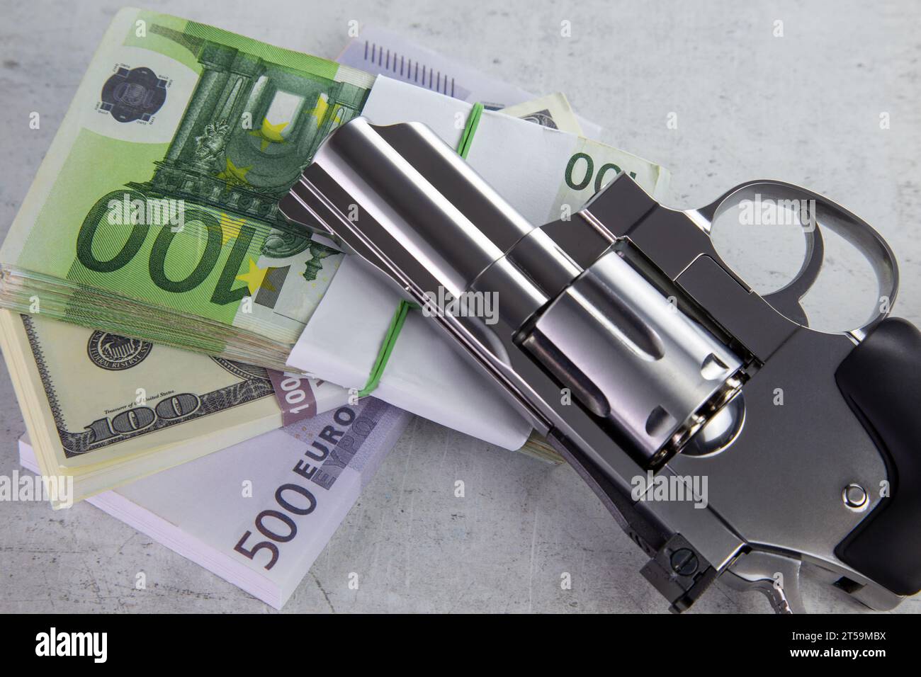 Eine Revolver-Pistole liegt auf einem Stapel Geld und schafft eine illustrative Szene, die Verbrechen und Bargeld symbolisiert Stockfoto