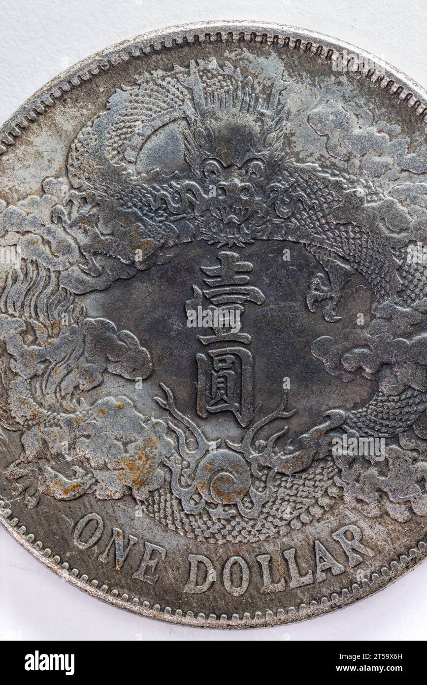 Makro einer 1-Dollar-Münze mit einem Drachen und asiatischem Text in der Mitte. Stockfoto