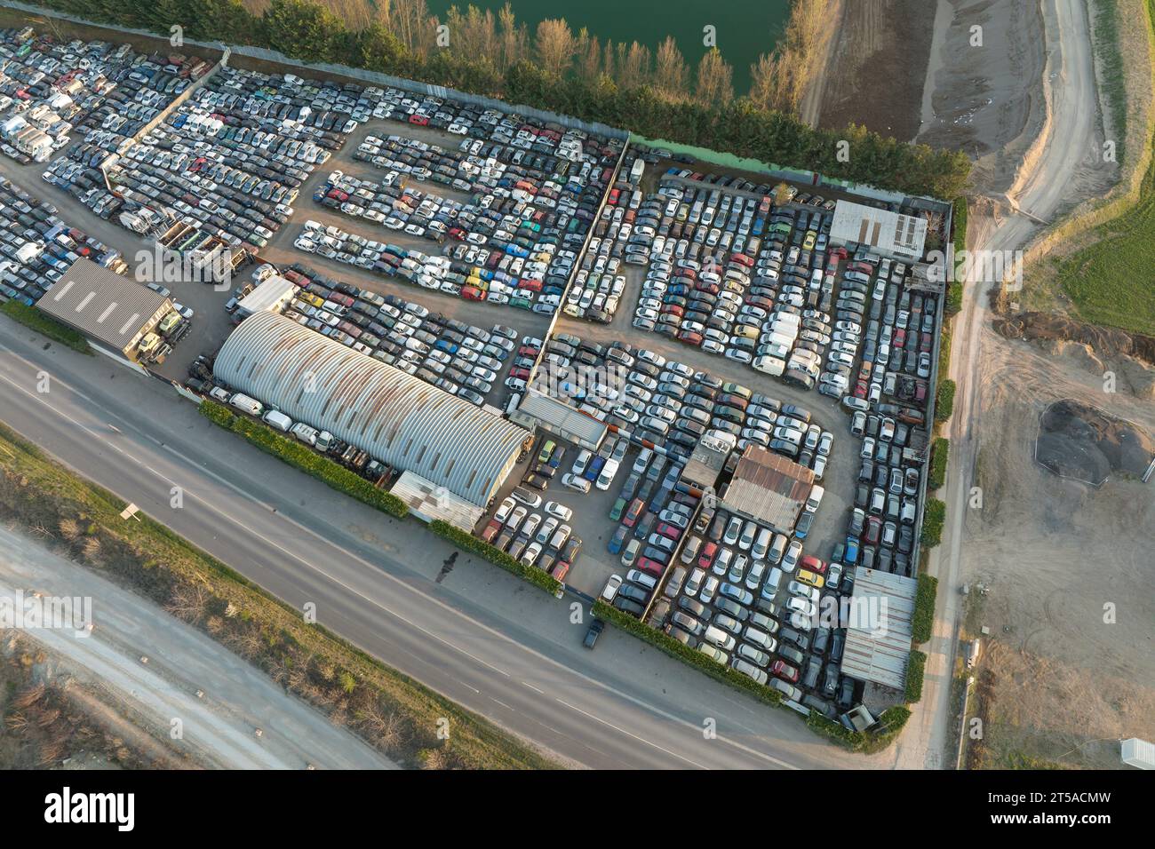 Luftaufnahme des großen Parkplatzes von Schrottplatz mit Reihen von weggeworfenen gebrochenen Autos. Recycling von Altfahrzeugen Stockfoto