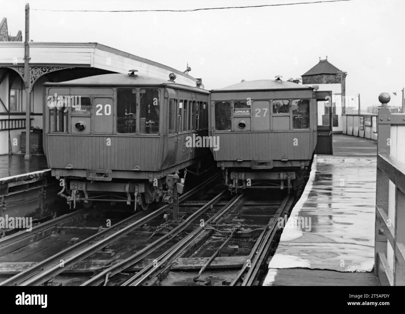 Zwei elektrische Züge auf der Liverpool Overhead Railway am Bahnhof Seaforth Sands, Merseyside, England, um 1950. Die Holzzüge 20 und 27 tragen auf ihren Zieltafeln die Bezeichnung „Dingle“, den Endbahnhof am anderen Ende der Strecke. Die Liverpool Overhead Railway verkehrte entlang der Liverpool Docks und wurde 1893 eröffnet. Sie war die weltweit erste elektrische Hochbahn und die zweitälteste elektrische U-Bahn der Welt. Auf ihrem Höhepunkt nutzten jedes Jahr fast 20 Millionen Menschen die Bahn. Ein Bericht aus dem Jahr 1955 zeigte, dass es unerschwingliche Reparaturen erforderte und die Bahn 1956 stilllegte. Stockfoto
