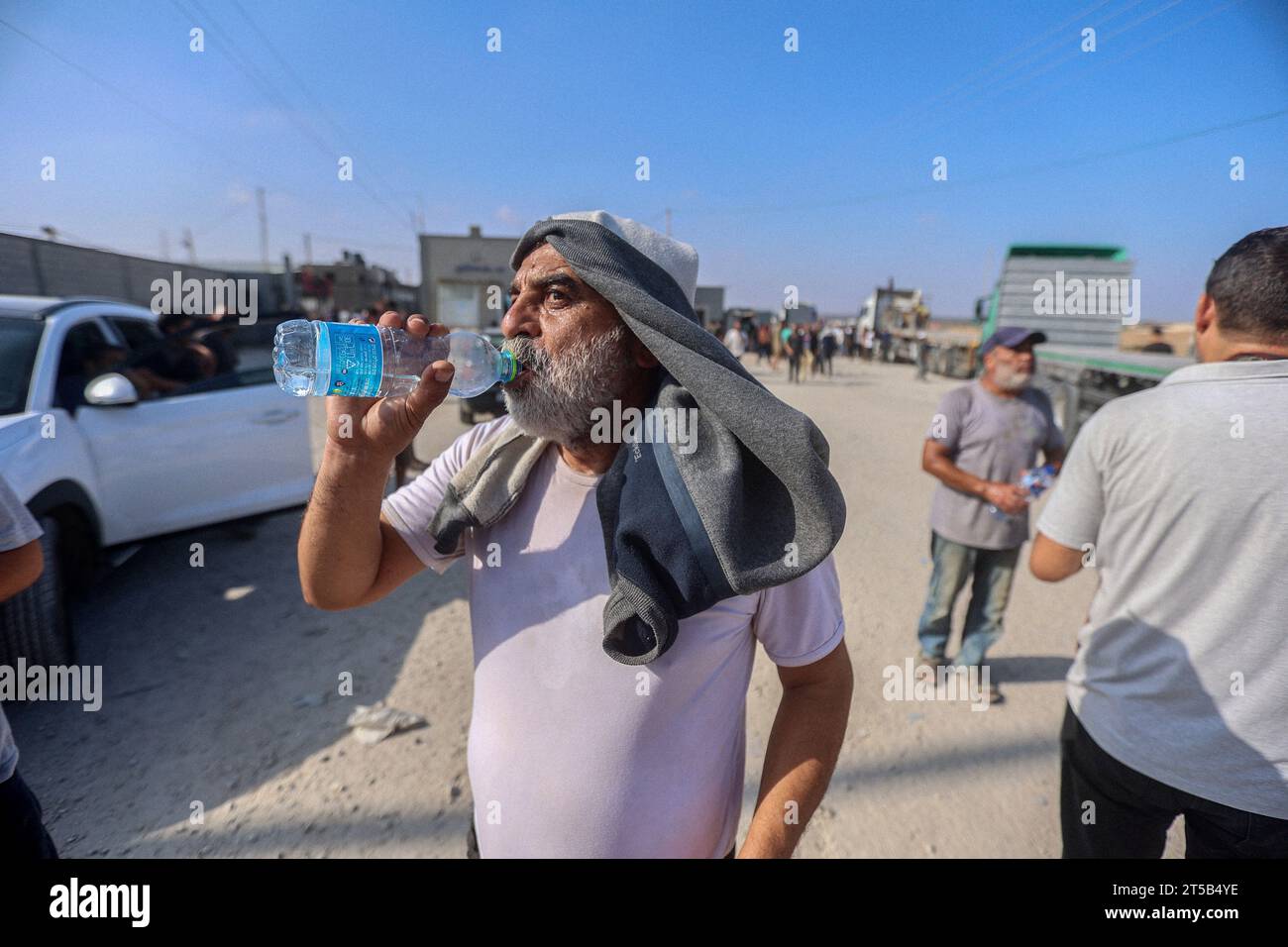 Ein palästinensischer Arbeiter trinkt Wasser, nachdem er auf der palästinensischen Seite des Grenzübergangs Rafah angekommen ist, nachdem er seit den Anschlägen vom 7. Oktober in Israel gestrandet war, reagiert, als er mit anderen in den Gazastreifen am Handelsgrenzübergang Kerem Schalom zu Israel im Süden des Gazastreifens zurückkommt palästinensische Enklave. Tausende von Zivilisten, sowohl Palästinenser als auch Israelis, sind seit dem 7. Oktober 2023 gestorben, nachdem palästinensische Hamas-Militante im Gazastreifen in den Süden Israels einmarschierten, bei einem beispiellosen Angriff, der einen Krieg auslöste, den Israel gegen die Hamas mit Vergeltungsbomben auf Gaza erklärt hatte. (Foto von Ahm Stockfoto