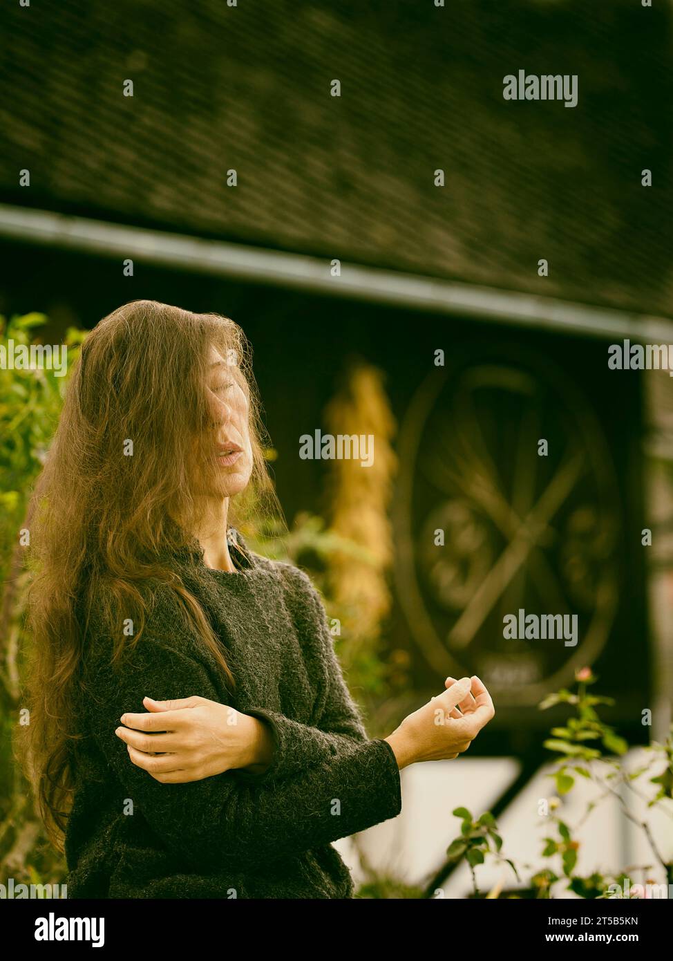 Frau in romantischer Pose zwischen rustikalen Häusern, Slowenien II Stockfoto