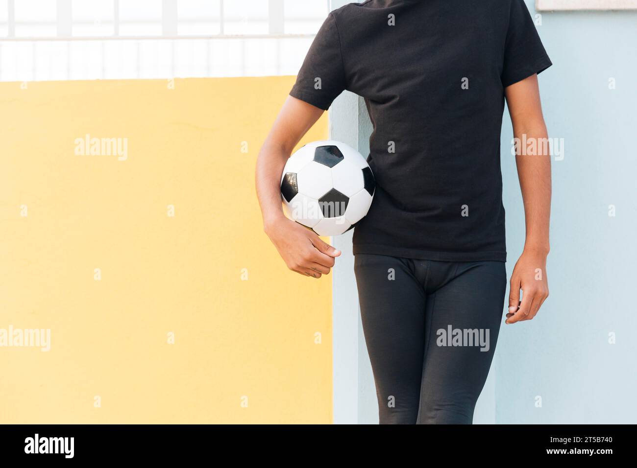 Beschneiden schwarzen Mann, der Fußball hält Stockfoto