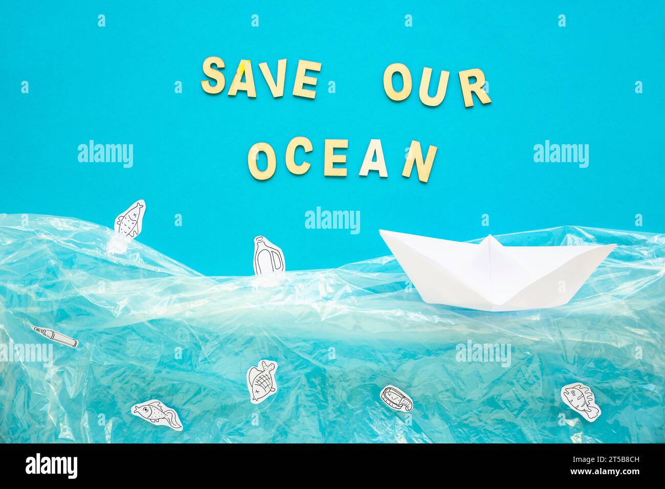Retten Sie unsere Ozeanworte Papierboot Stockfoto
