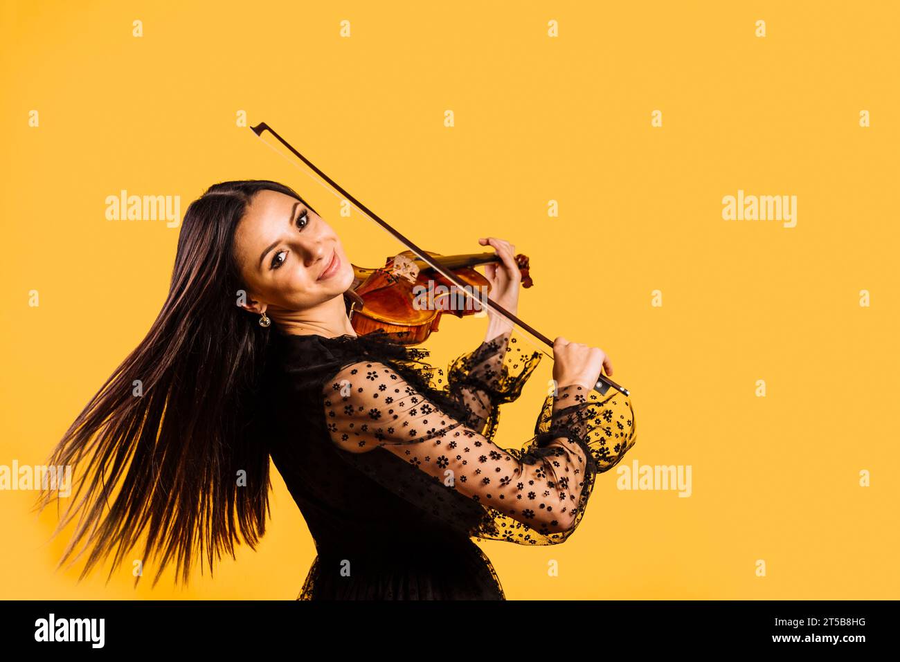 Lächelndes Mädchen, das Geige spielt Stockfoto