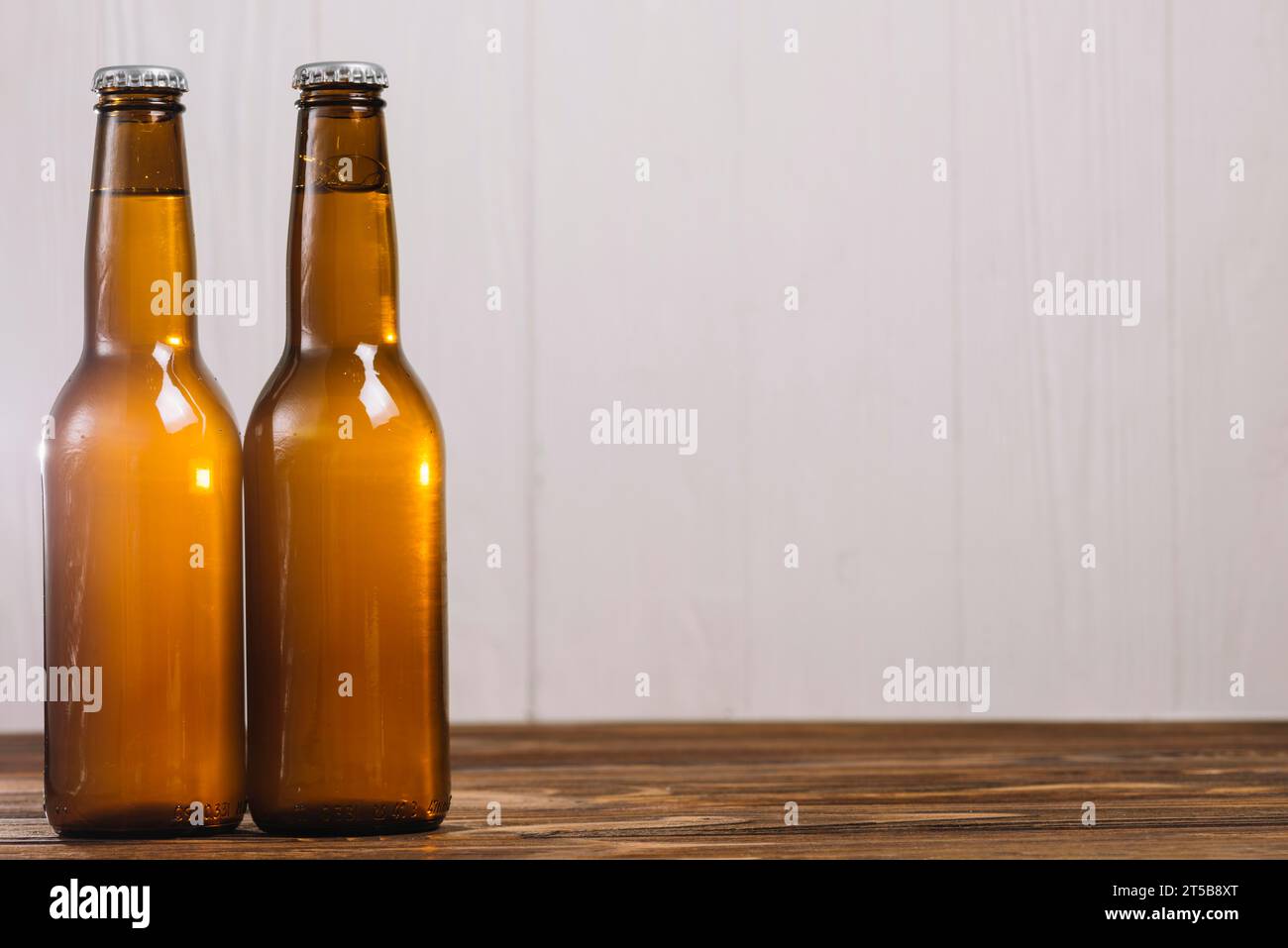 Zwei Bierflaschen mit Holzoberfläche Stockfoto