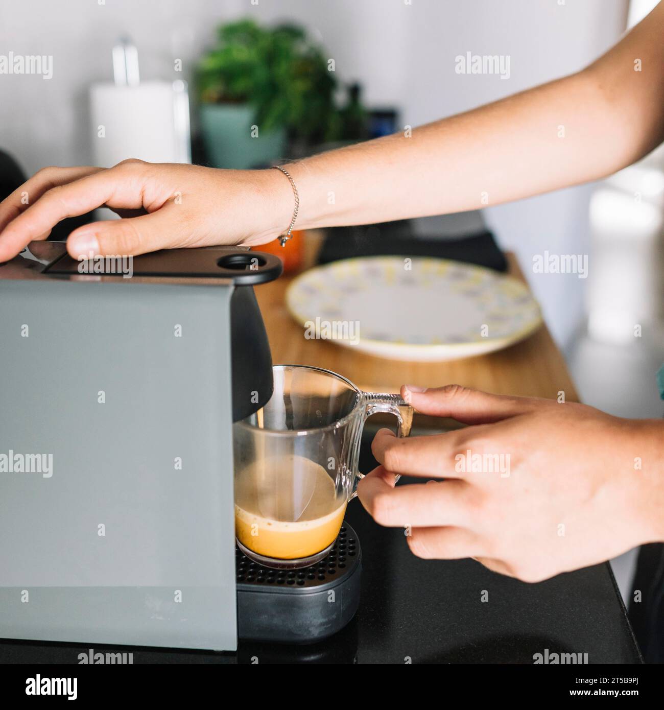 Nahaufnahme Frau, die Kaffee aus der Kaffeemaschine nimmt Stockfoto