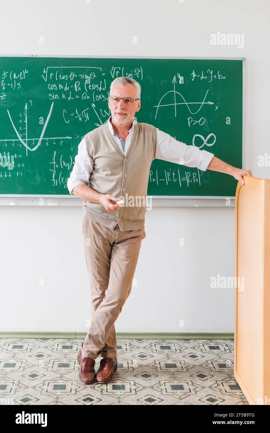 Selbstbewusster alter Mathelehrer, der Klasse aussieht Stockfoto