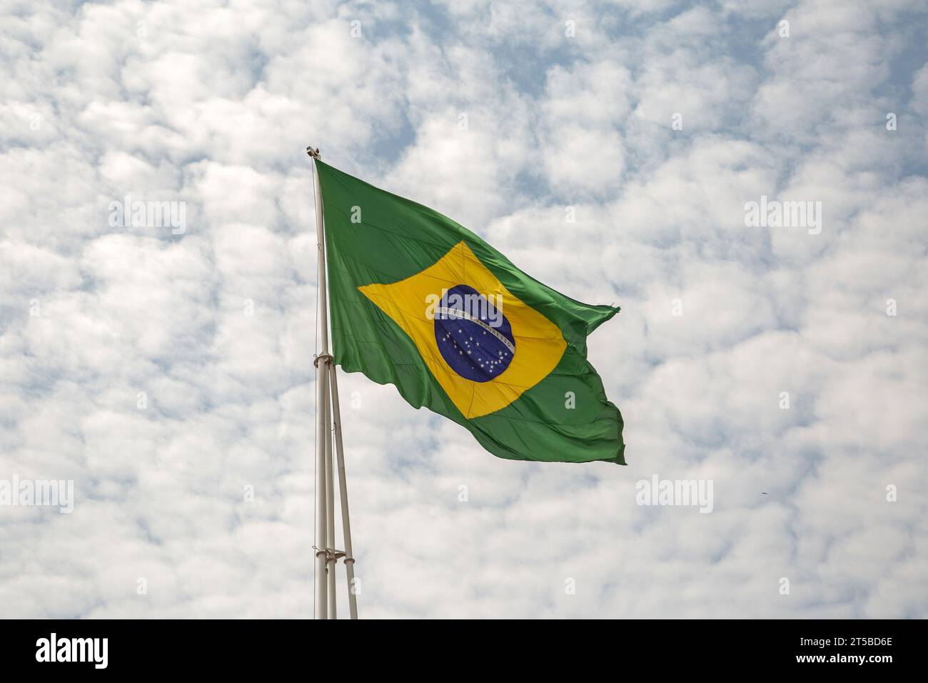 Goiânia, Goias, Brasilien – 30. September 2023: Eine brasilianische Flagge flattert an einem Tag mit vielen Wolken am Himmel im Wind. Stockfoto