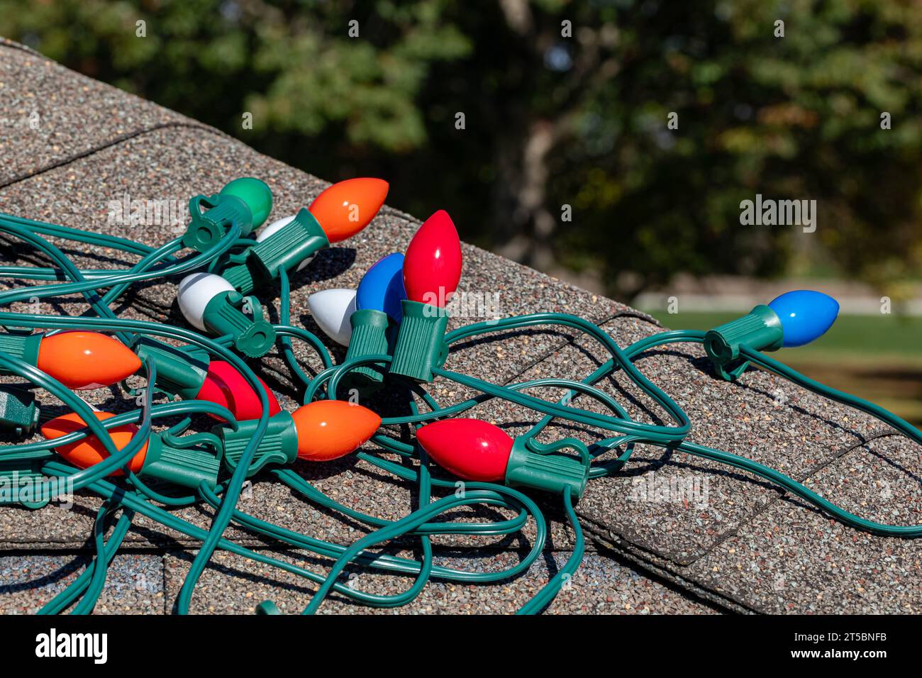 Verwickelte Weihnachtsbeleuchtung auf dem Dach des Hauses. Feiertagsdekoration Sicherheits-, Licht- und Unfallverhütungskonzept. Stockfoto