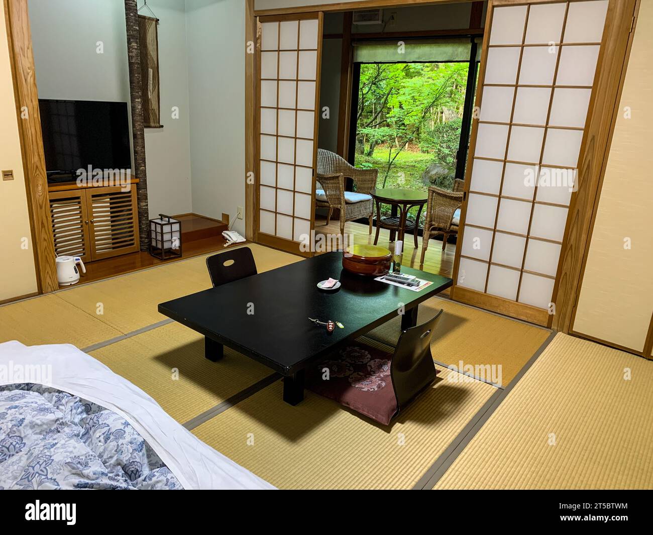 Japan, Kyushu. Ryokan-Zimmer mit Futon unten links, Gartenblick. Stockfoto