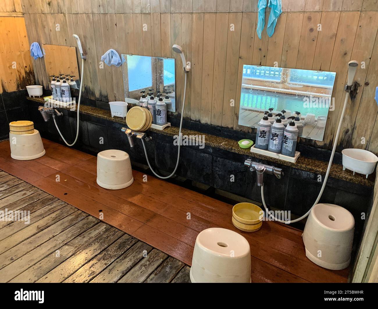 Japan, Kyushu. Eine Onsen-Thermalbadeanlage. Bereich zum Duschen vor dem Betreten des heißen Quellwassers. Stockfoto