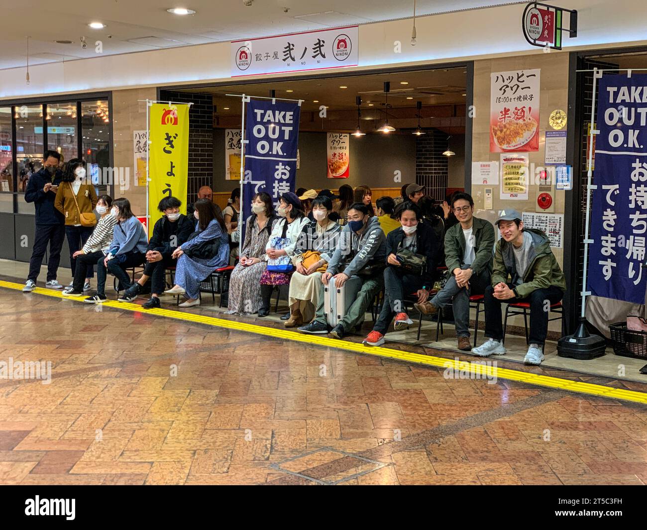 Fukuoka, Hakata, Japan. Kunden, die auf einen Sitzplatz in einem beliebten Restaurant, Hakata City Mall, Hakata Bahnhof warten. Stockfoto