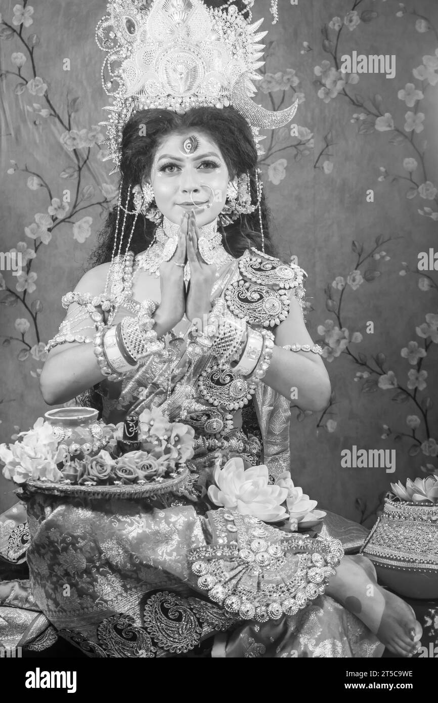 Porträt des wunderschönen indischen Mädchens von Durga Idol Agomoni Konzept Innenfoto mit traditionellem indischem Saree, Goldschmuck und Armreifen. Maa Durga. Stockfoto