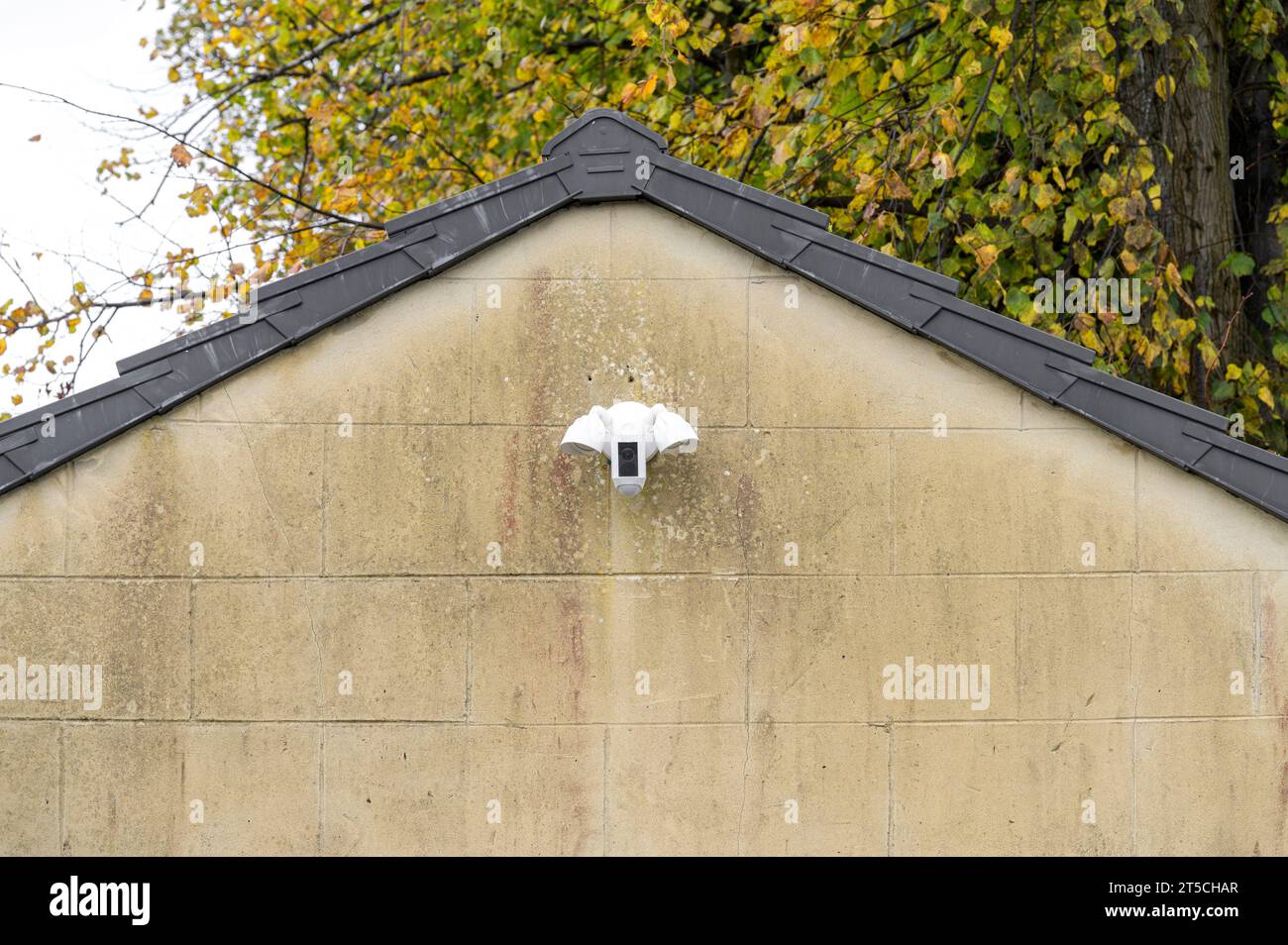 Flutlicht und Überwachungskamera an einer Garagenwand zur Abschreckung von Verbrechen, Schottland, Großbritannien. Europa Stockfoto
