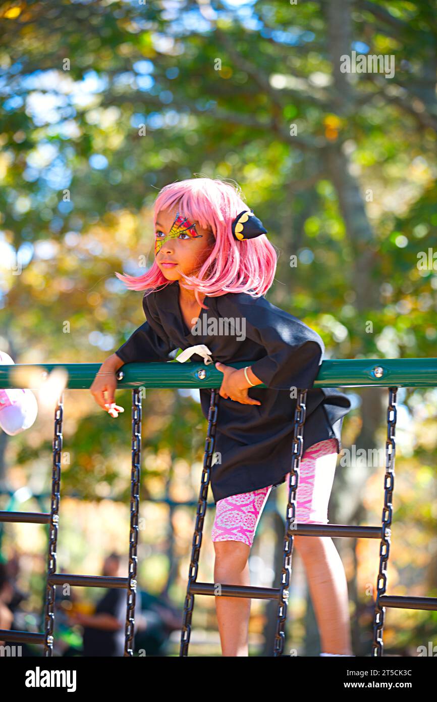Halloweenpalooza - Dennis, Massachusetts auf Cape Cod. Eine Familienfeier an Halloween. Ein Mädchen mit magentafarbenen Haaren im Dschungelstudio Stockfoto
