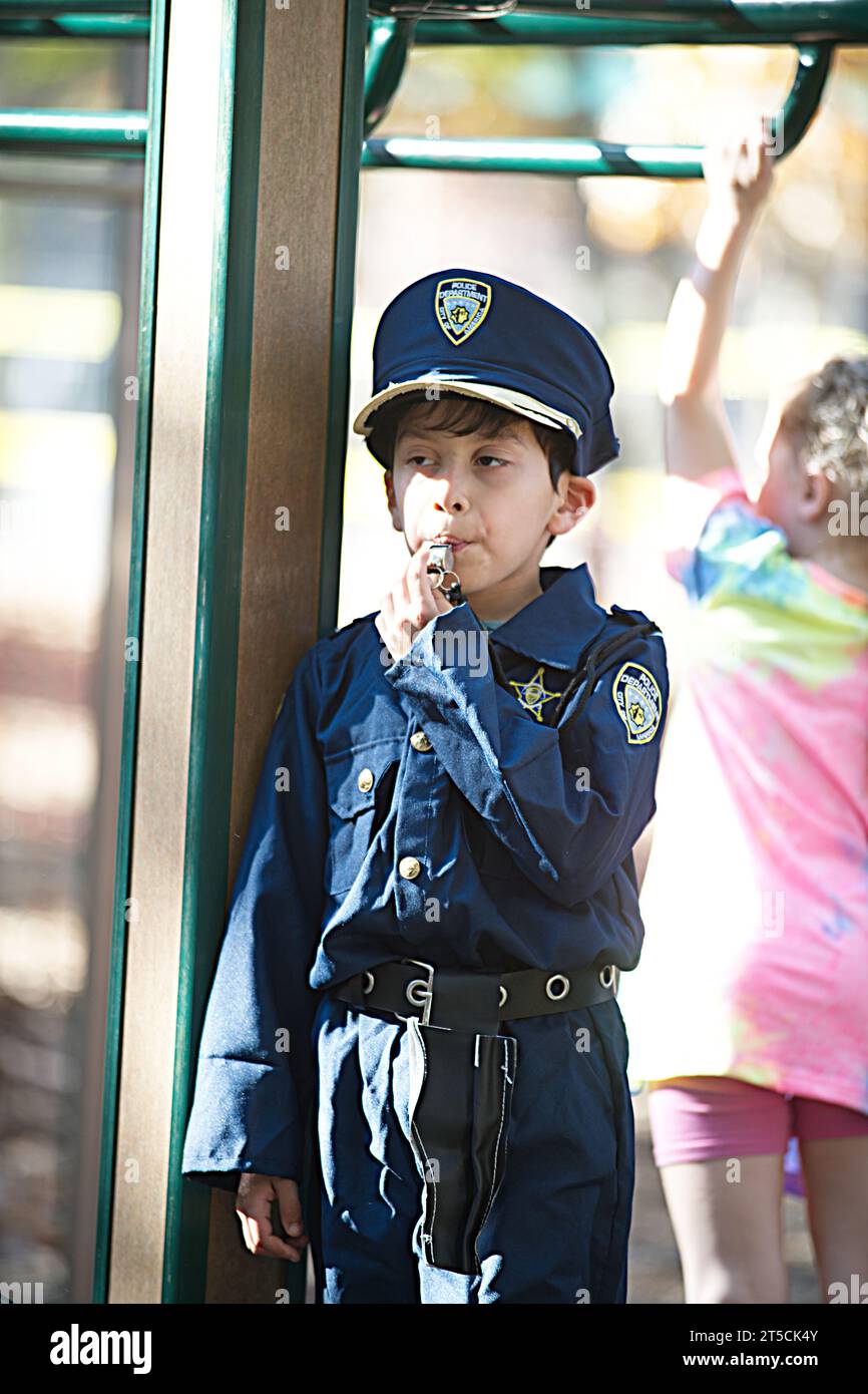 Halloweenpalooza - Dennis, Massachusetts auf Cape Cod. Eine Familienfeier an Halloween. Ein kleiner Junge in Polizistenuniform Stockfoto