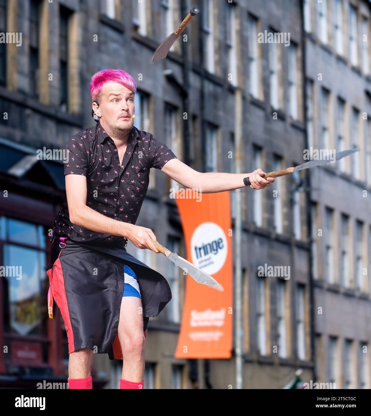 Messerjongleur beim Edinburgh Fringe Festival mit einer scharfen Klinge, die auf sein Gesicht zeigt Stockfoto