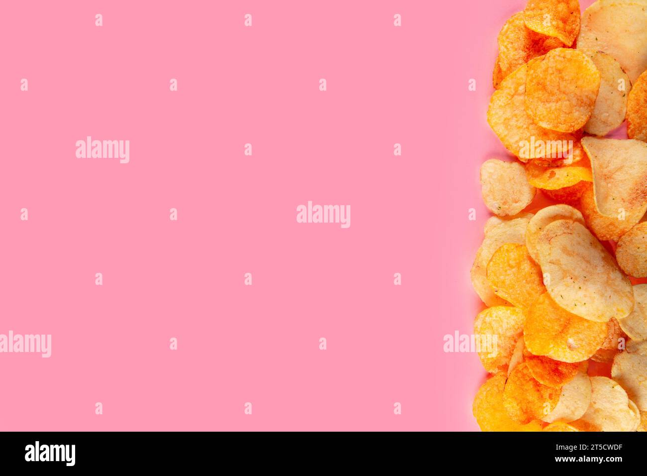 Rand von Kartoffelchips isoliert auf rosa Hintergrund. Snackbarer Chip in Bite-Size-Größe Stockfoto