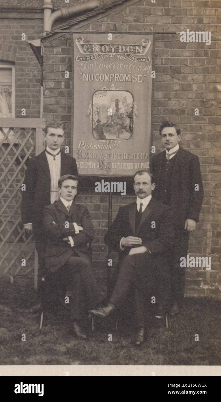 Croydon Kensit Crusade: Foto von vier elegant gekleideten Männern mit religiösem Banner aus dem frühen 20. Jahrhundert. John Kensit (1853–1902) war der Gründer der Protestant Truth Society und kämpfte gegen den Anglo-Katholizismus und den „Ritualismus“ in der Church of England. Das Banner enthält „Kensits Botschaft „kein Kompromiss““, eine Illustration von Hugh Latimer, der auf dem Scheiterhaufen verbrannt wird („Latimers Kerze“) und die Beschriftung „Protestanten!!! Bleib fest in der Freiheit, mit der Christus dich befreit hat. Stockfoto