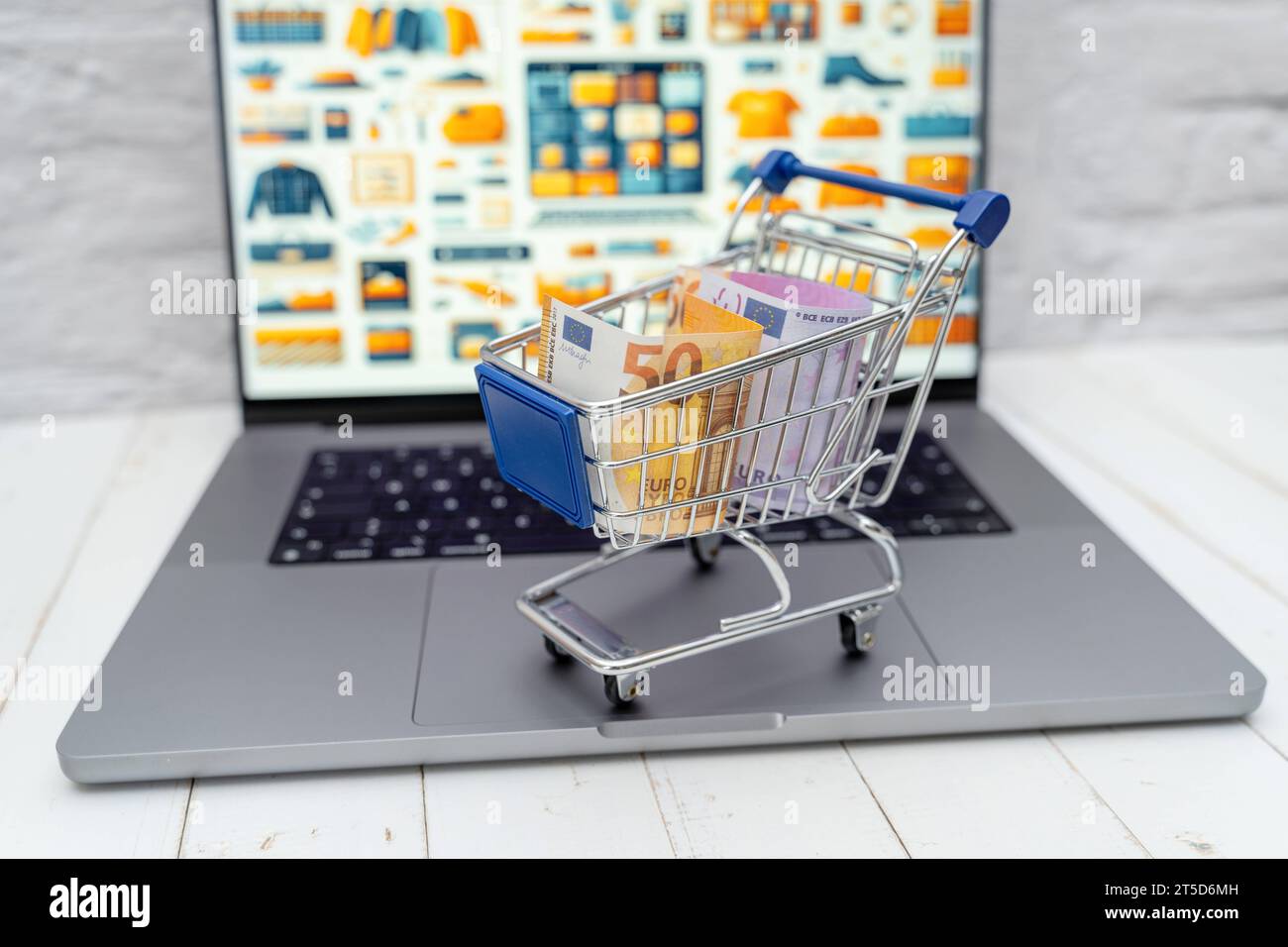 Augsburg, Bayern, Deutschland - 4. November 2023: Einkaufswagen mit Geldscheinen auf einem Laptop Computer vor einem Internet Online-Shop *** Einkaufswagen mit Banknoten auf einem Laptop vor einem Internet-Shop Credit: Imago/Alamy Live News Stockfoto
