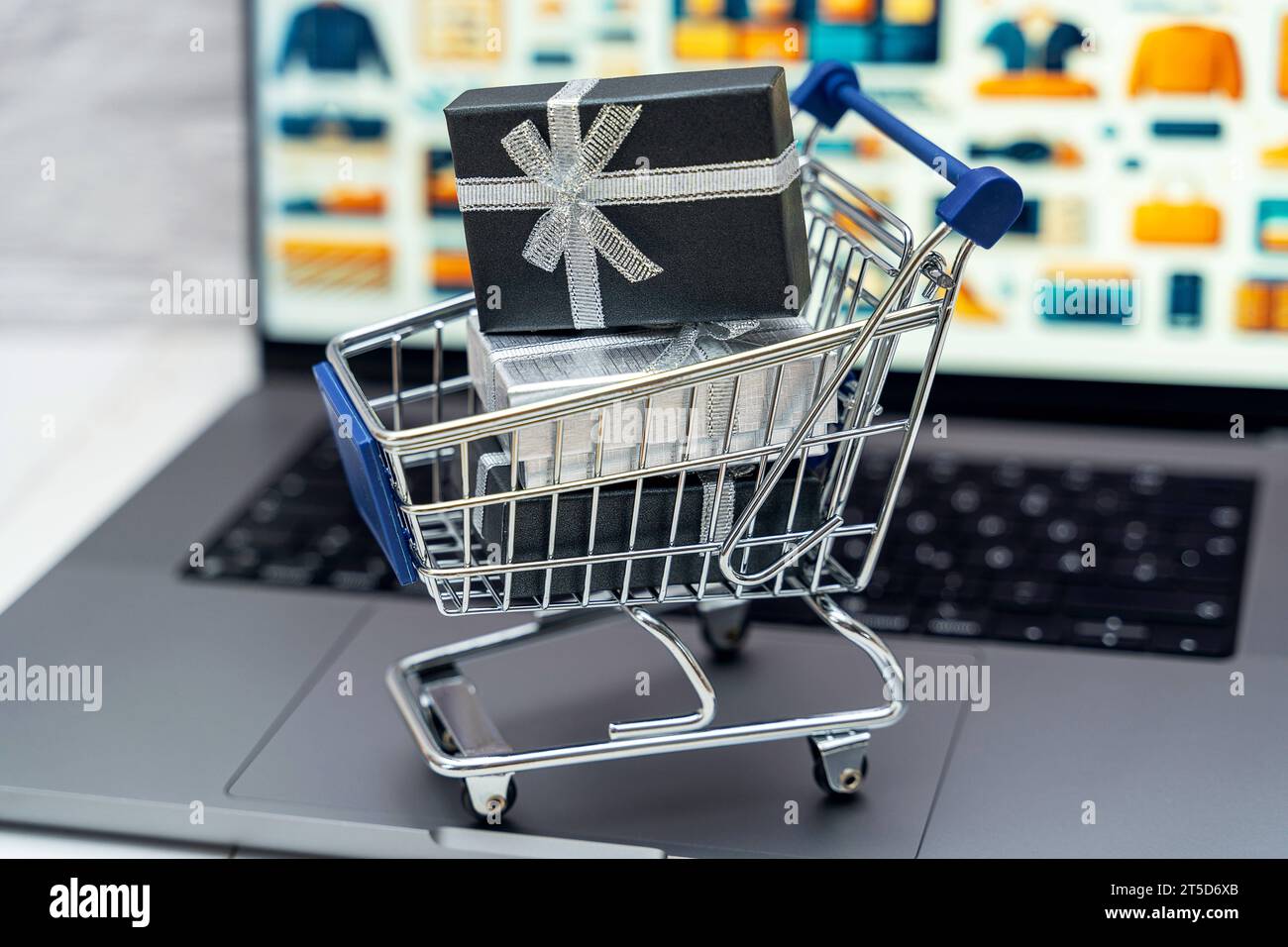 Augsburg, Bayern, Deutschland - 4. November 2023: Pakete mit Geschenken in einem Einkaufswagen auf einem Laptop Computer vor einer Online-Shop Website. Geschenke Einkaufen und bestellen im Internet Konzept *** Geschenkpakete im Warenkorb auf einem Laptop vor einer Online-Shop-Website. Geschenkeinkauf und -Bestellung im Internet Konzept Credit: Imago/Alamy Live News Stockfoto