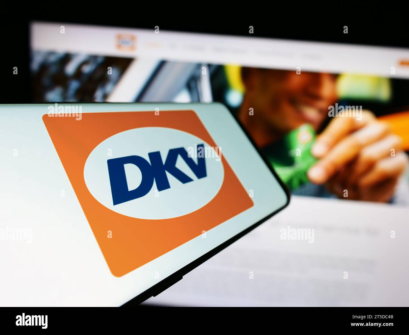 Mobiltelefon mit Logo des deutschen B2B-Zahlungsunternehmens DKV Mobility vor der Business-Website. Fokussieren Sie sich auf die linke Mitte des Telefondisplays. Stockfoto