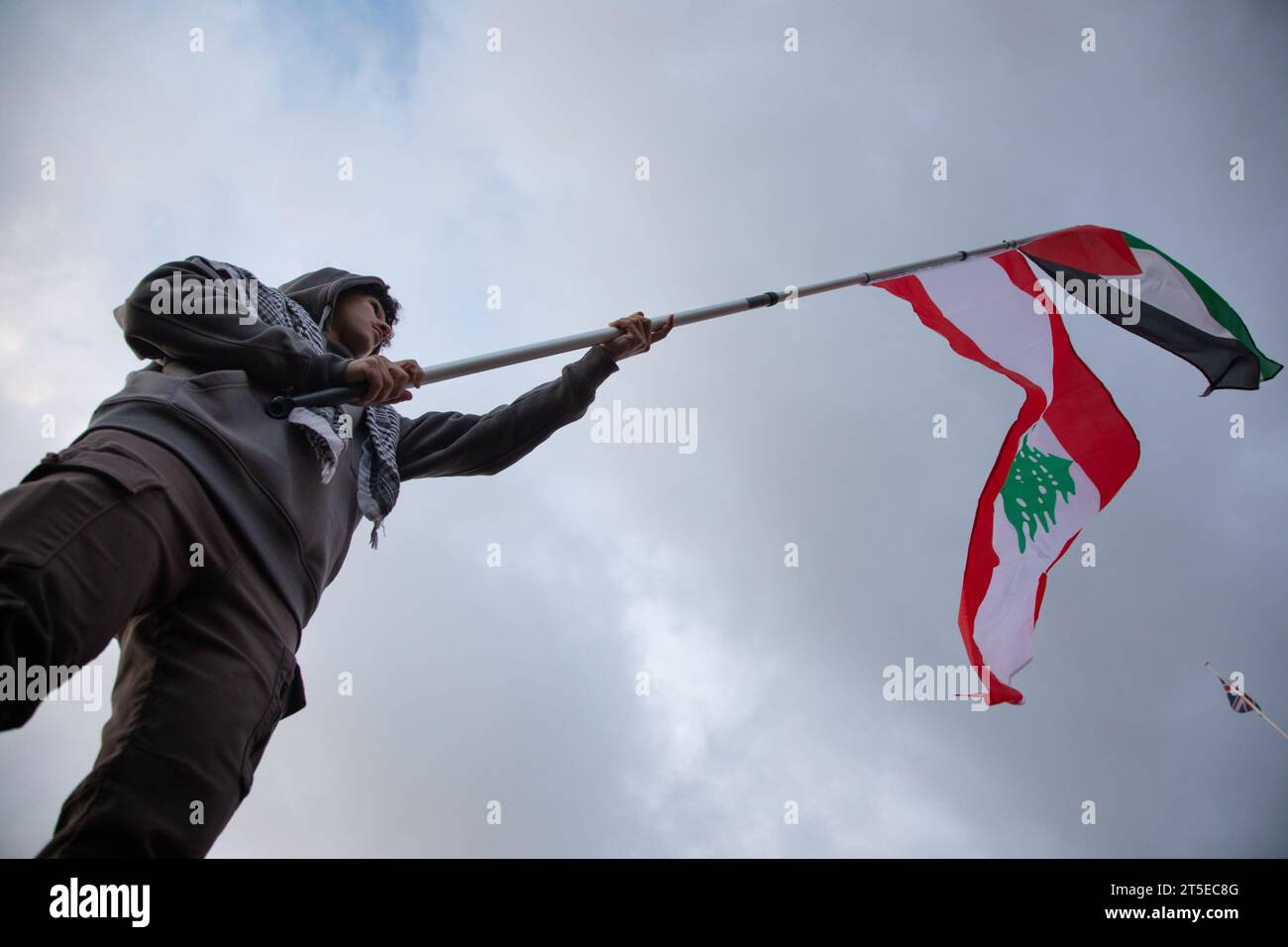 London, Großbritannien. November 2023. Ein junger Mann schwingt palästinensische und libanesische Flaggen auf dem Trafalgar-Platz, auf dem Tausende zu einem Waffenstillstand in Gaza aufgerufen haben. Der Protest folgt auf den jüngsten Ausbruch der Gewalt zwischen Hamas und Israel. Quelle: Kiki Streitberger/Alamy Live News Stockfoto