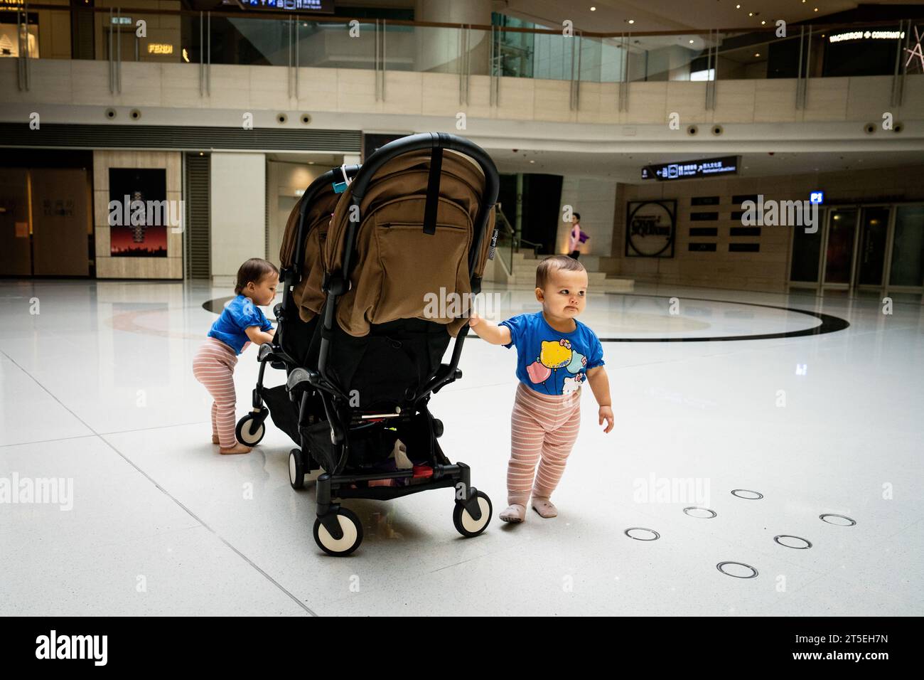 Hongkong. November 2023. Zwillinge spielen am 5. November 2023 in einem Einkaufszentrum an der Kowloon Station in Hongkong. Credit: Matt Hunt/Neato/Alamy Live News Credit: Matt Hunt/Neato/Alamy Live News Stockfoto