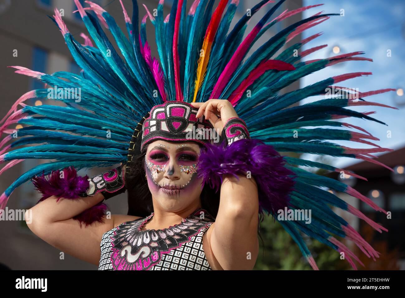 Seattle, Washington, USA. November 2023. Eine junge Frau hält sich fest, wenn der Wind ihre Federkopfhaube bei der jährlichen Feier des Día de los Muertos von El Centro de la Raza bedroht. Quelle: Paul Christian Gordon/Alamy Live News Stockfoto