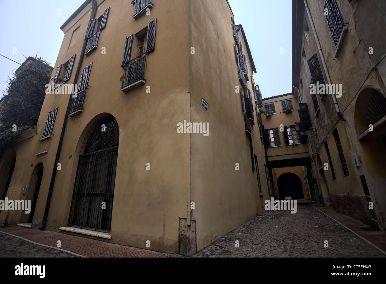 Ecke zwischen engen und kopfsteingepflasterten Gassen an bewölktem Tag in einer italienischen Stadt Stockfoto