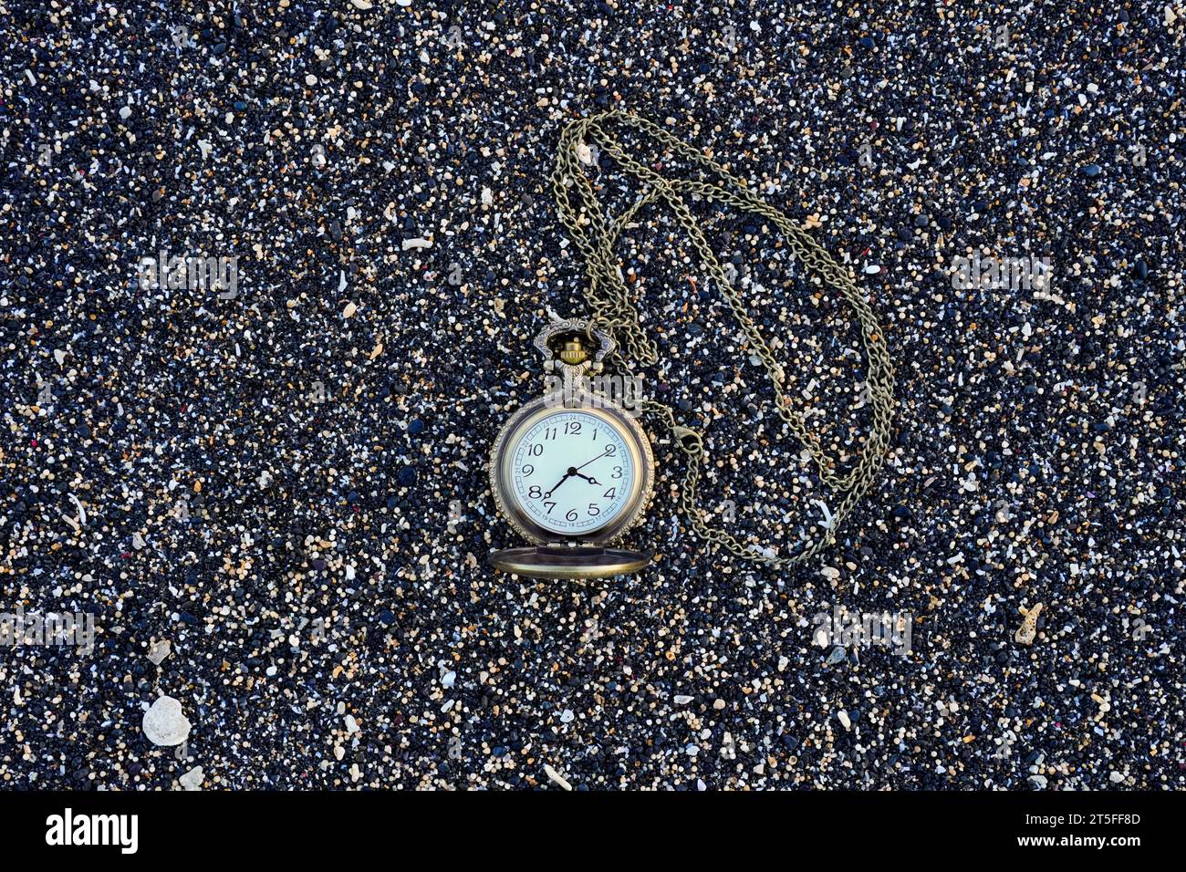 Fesselndes Bild einer goldfarbenen Taschenuhr am Strand. Mit Kopierraum für Text Stockfoto