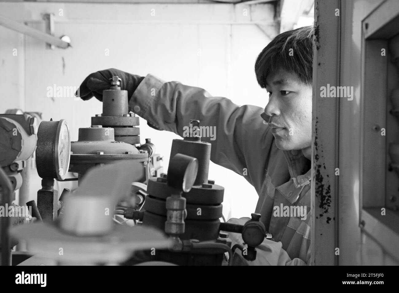 TANGSHAN - 20. DEZEMBER: Der Arbeiter in einer komprimierten Erdgasbox und Betrieb, in einem Produktionsunternehmen, am 20. Dezember 2013, Stadt tangshan, Stockfoto