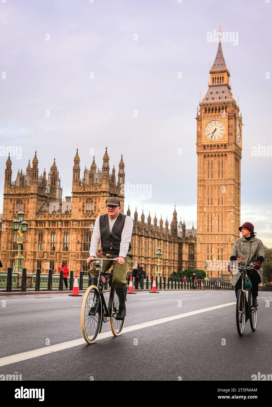 London, Großbritannien. November 2023. Zwei Radfahrer in viktorianischen Outfits nehmen am Lauf Teil. Der RM Sotheby's London to Brighton Veteran Car Run, eines der am längsten laufenden Motorsportveranstaltungen weltweit, startet im Hyde Park, wo sie die Mall, Whitehall und Westminster Bridge besuchen, bevor sie ihre Reise an die Küste von Sussex fortsetzen. Ein teilnehmendes Fahrzeug muss vor 1905 an dem Rennen teilnehmen. Quelle: Imageplotter/Alamy Live News Stockfoto