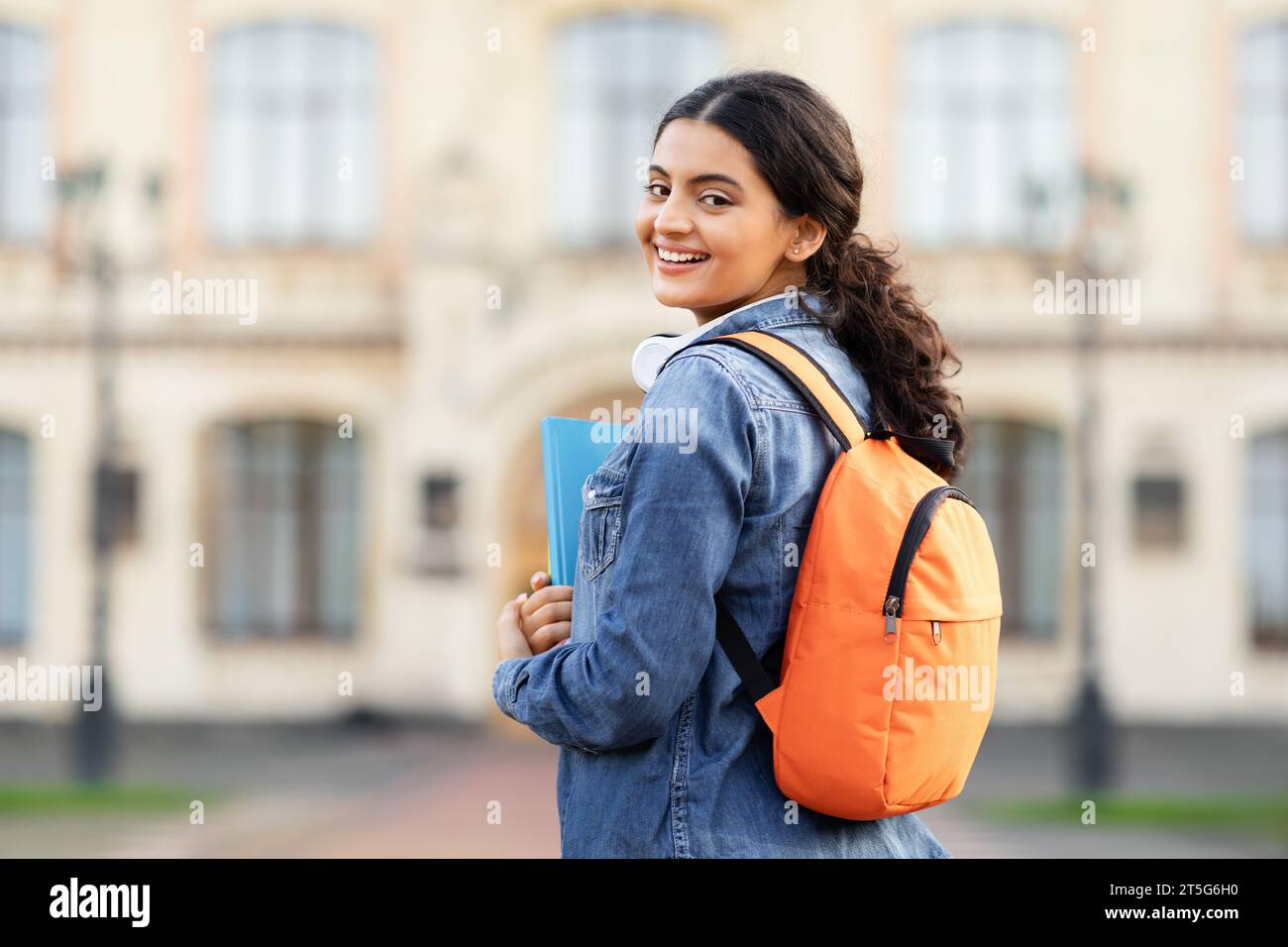 Strahlende junge indische Gelehrte mit ihren akademischen Büchern und Tasche Stockfoto