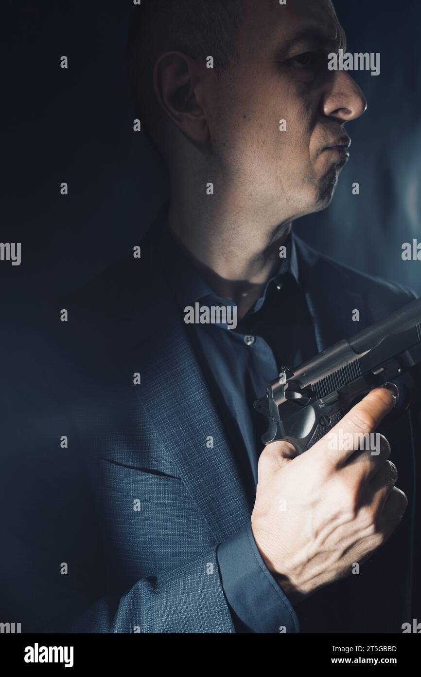 Söldner-Killer Spion-Attentäter Detective mit Pistole Portrait Studio Foto gemacht. Stockfoto