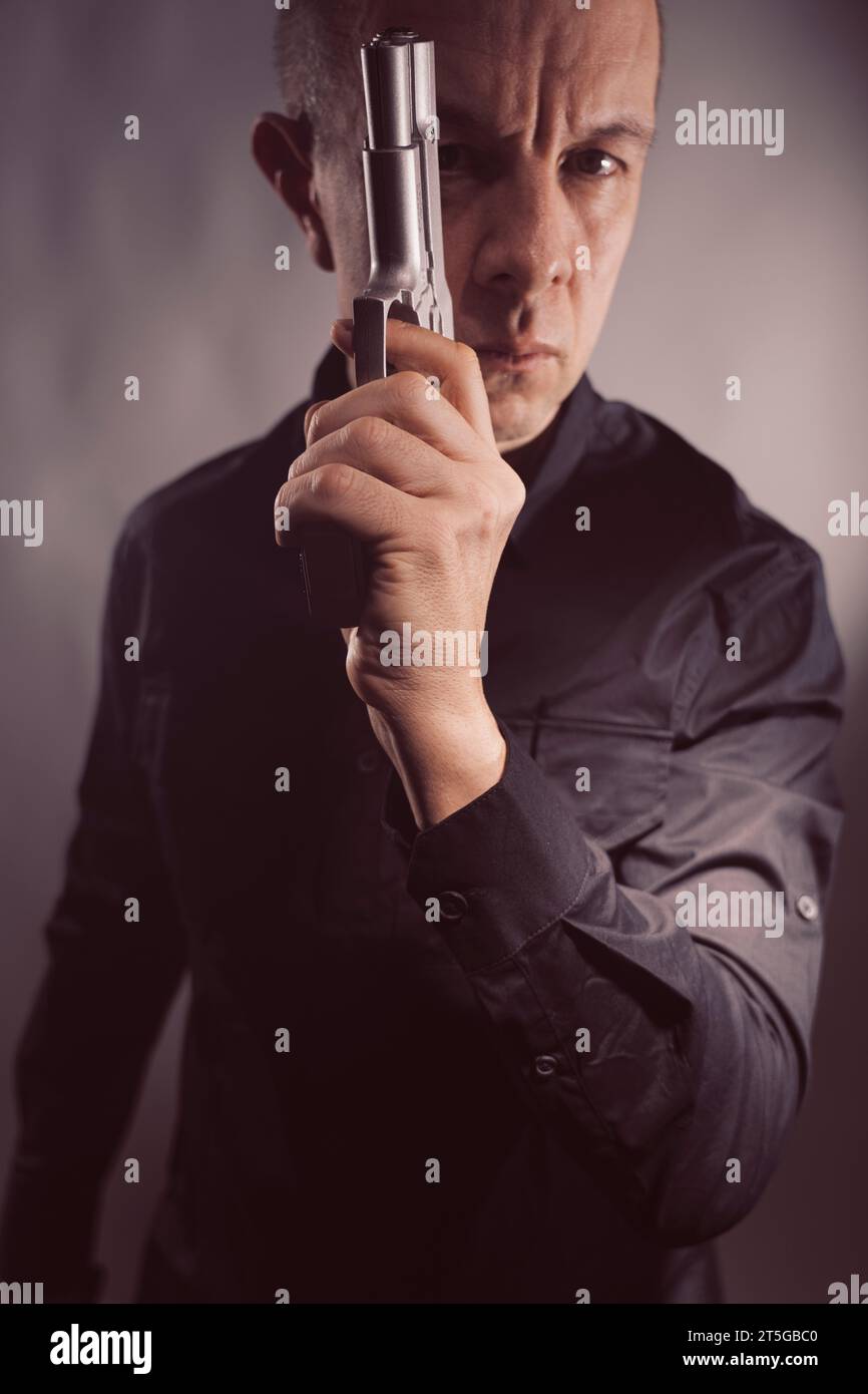Söldner-Killer Spion-Attentäter Detective mit Pistole Portrait Studio Foto gemacht. Stockfoto