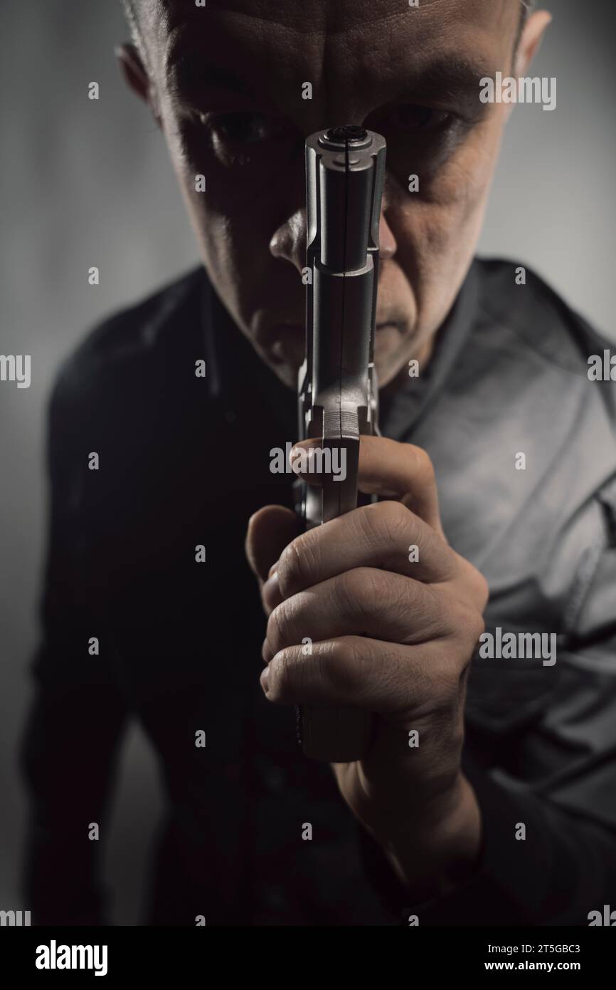 Söldner-Killer Spion-Attentäter Detective mit Pistole Portrait Studio Foto gemacht. Stockfoto