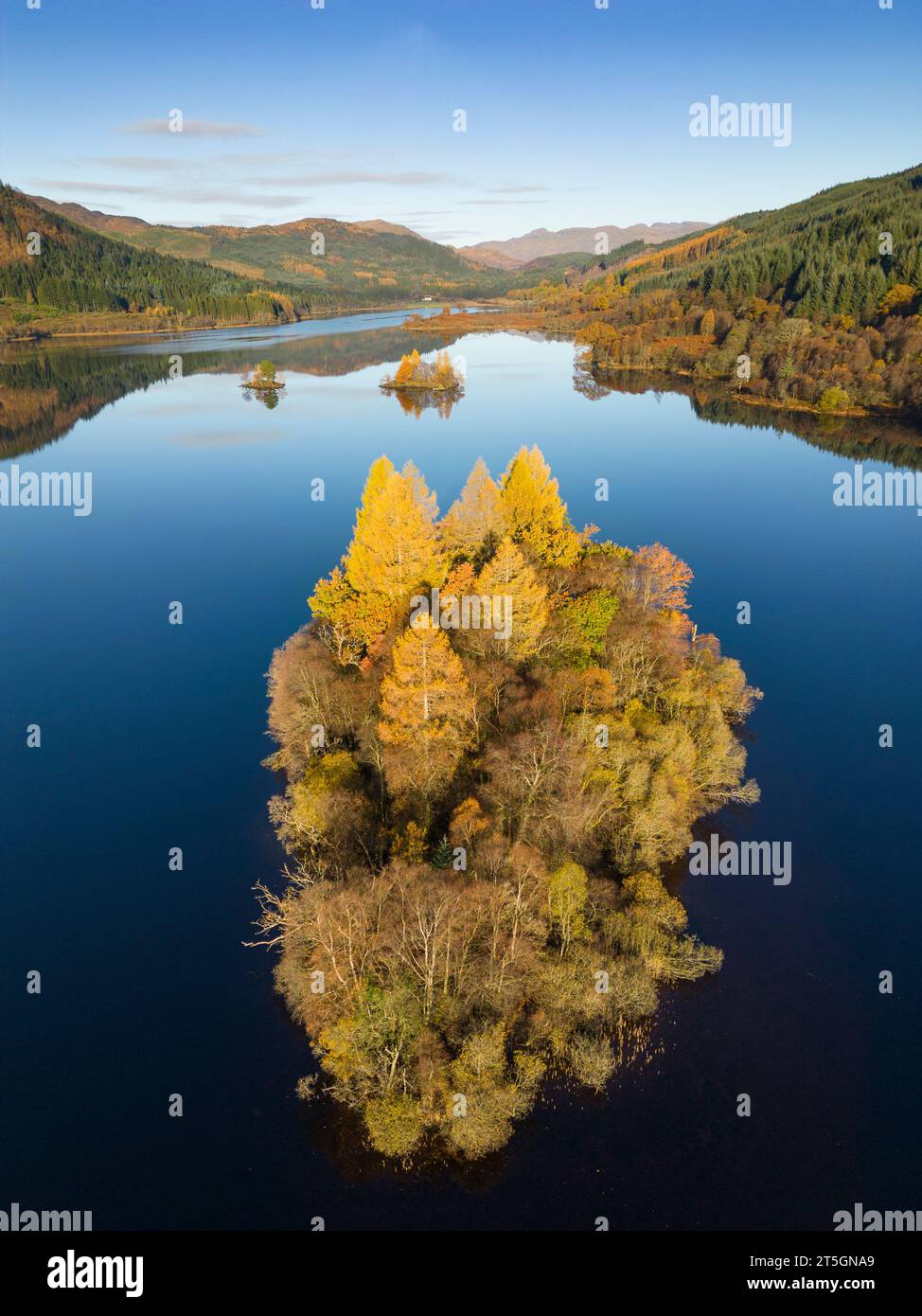 Aberfoyle, Stirling, Schottland, Großbritannien. November 2023. Aus der Vogelperspektive auf eine kleine, mit Bäumen bedeckte Insel in der Mitte von Loch Chon in den Farben des Spätherbstes Stockfoto