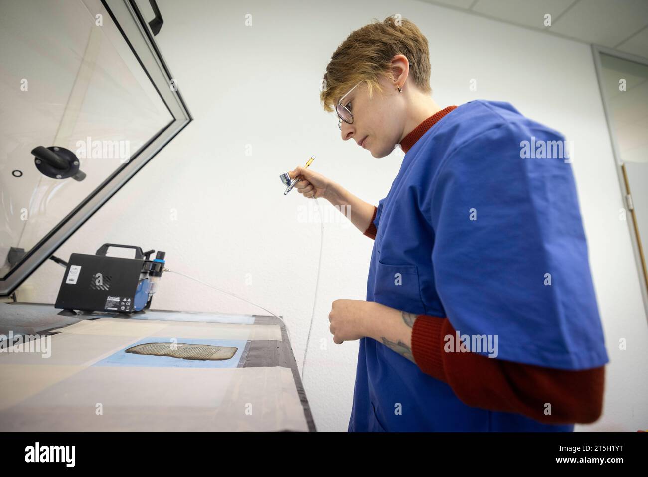 Papierwerkstatt der Klassik-Stiftung der Anna-Amalai-Bibliothek in Weimar, Thüringen. Foto vom 02.11.2023: Mit einem Airbrush-Verfahren wird die Mikrozellulose auf die beschaedigten Seiten aufgebracht in der Restaurierungswerkstatt werden mehr als 1, 5 Millionen Buchseiten und Tausende Dokumente restauriert. Viele von ihnen fielen dem Feuer der Bibliothek im Jahr 2004 zum Opfer. Siehe epd-Bericht vom 05.11.2023 NUR REDAKTIONELLE VERWENDUNG *** Papierwerkstatt der Klassischen Stiftung der Anna Amalai Bibliothek in Weimar, Thüringen Foto vom 02 11 2023 die Mikrocellulose wird auf die beschädigte pag aufgebracht Stockfoto