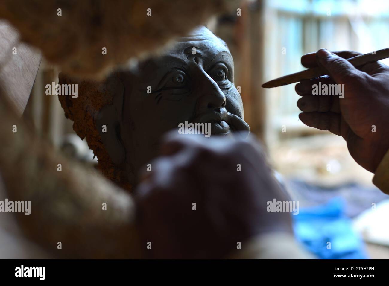 Handwerker, der einem Statut aus Ton Gestalt gibt Stockfoto