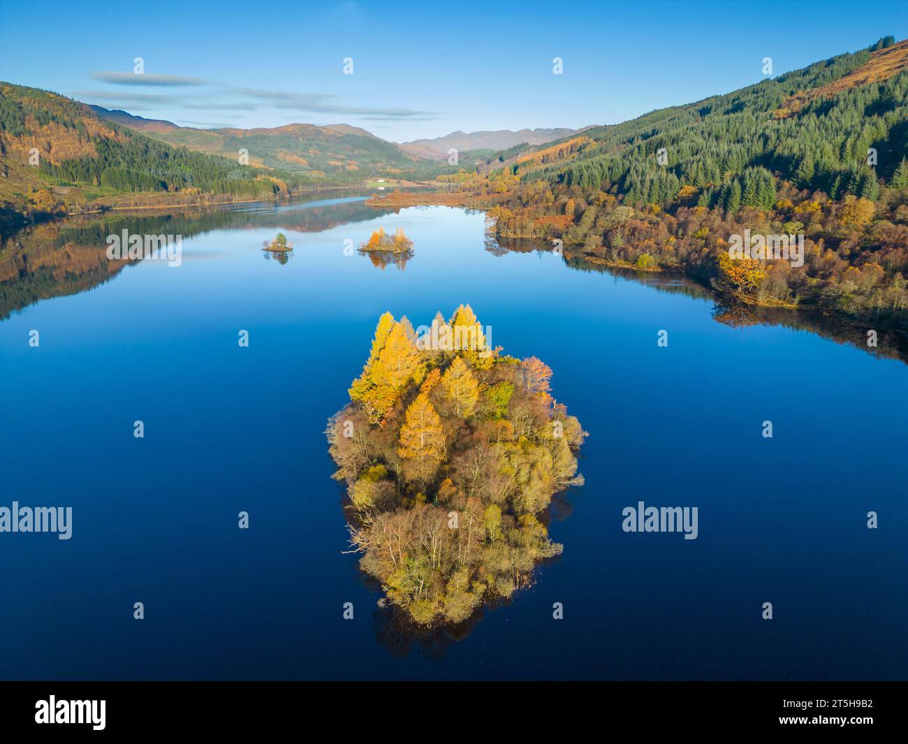 Luftaufnahme der mit Bäumen bewachsenen Insel in Herbstfarben auf Loch Chon, Kinlochard, Schottland, Großbritannien Stockfoto