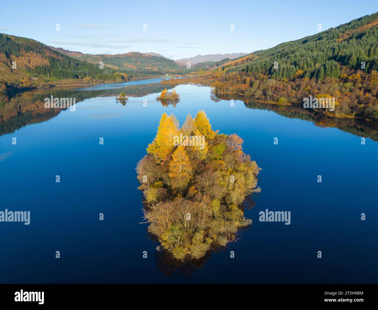 Luftaufnahme der mit Bäumen bewachsenen Insel in Herbstfarben auf Loch Chon, Kinlochard, Schottland, Großbritannien Stockfoto