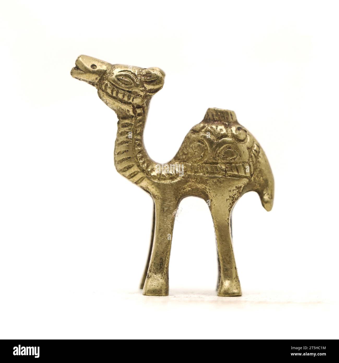 Eine alte Kamelfigur mit wunderschönen Details aus goldenem Messingmetall, isoliert auf weißem Hintergrund Stockfoto