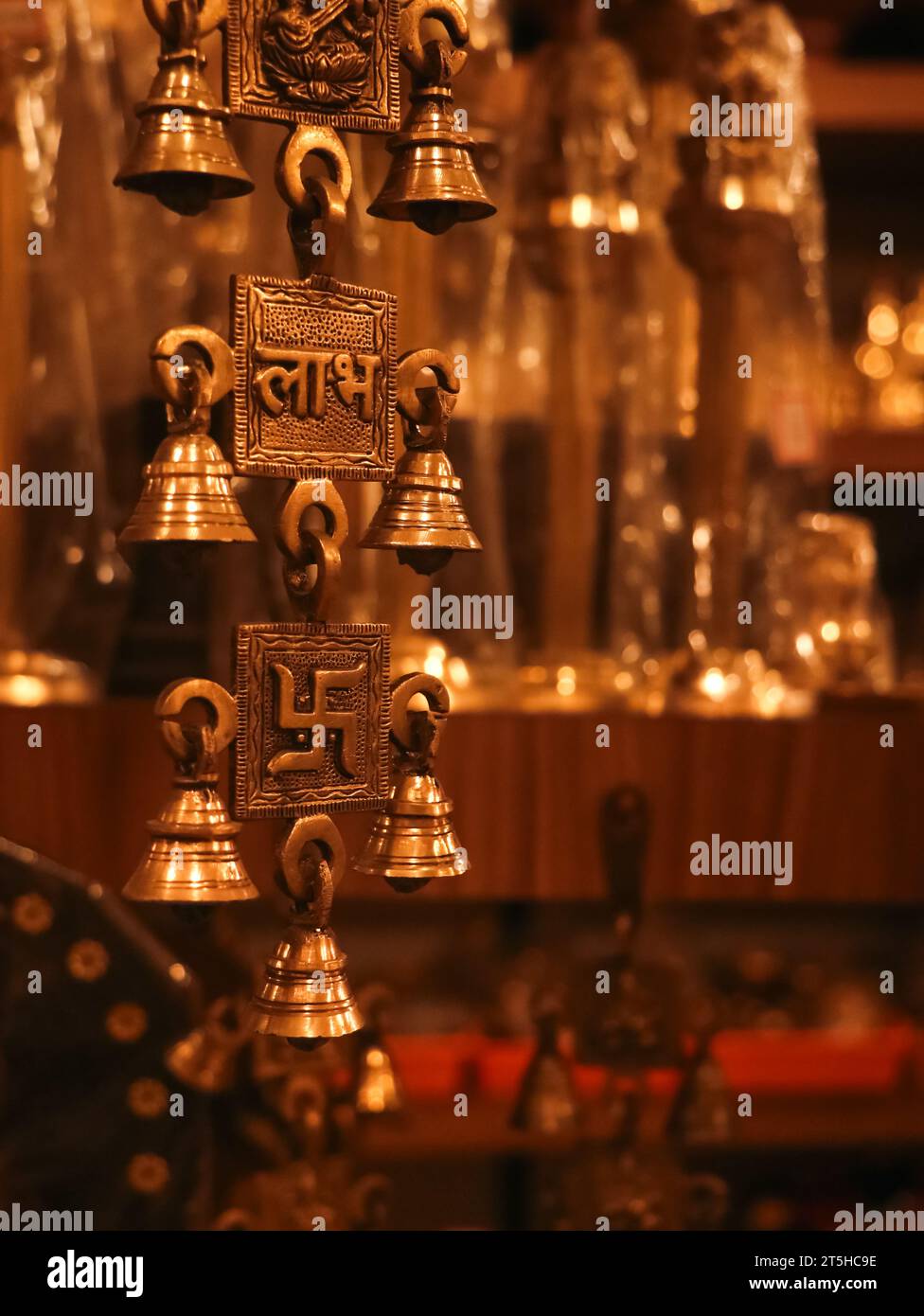 Alte, Souvenir hängende Messingglocken mit religiösen Symbolen aus einem antiken indischen Souvenirladen Stockfoto