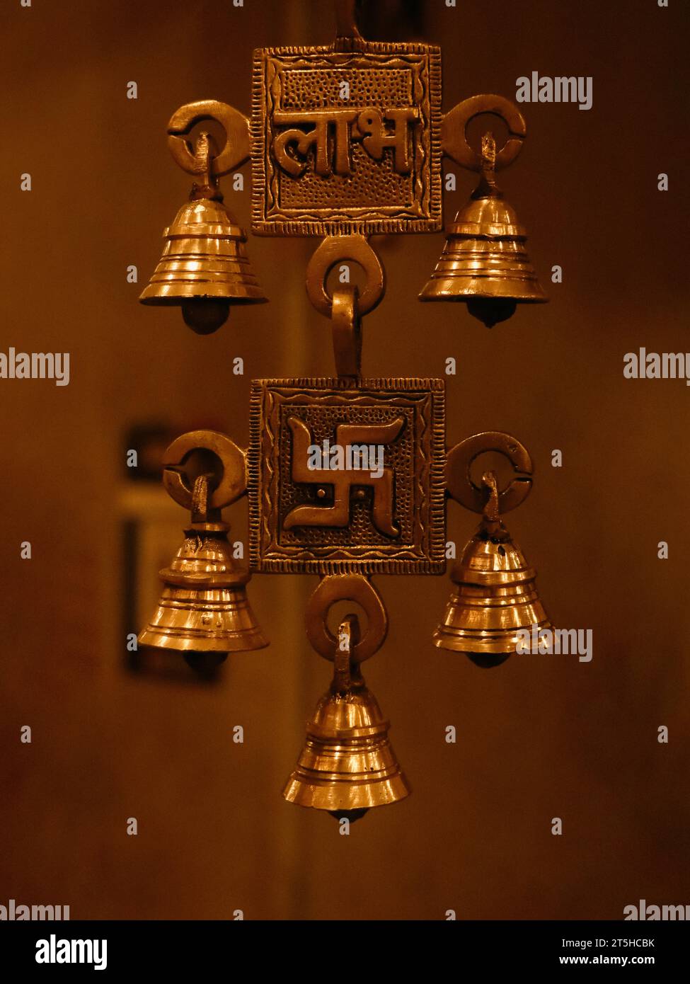 Alte, Souvenir hängende Messingglocken mit religiösen Symbolen aus einem antiken indischen Souvenirladen Stockfoto