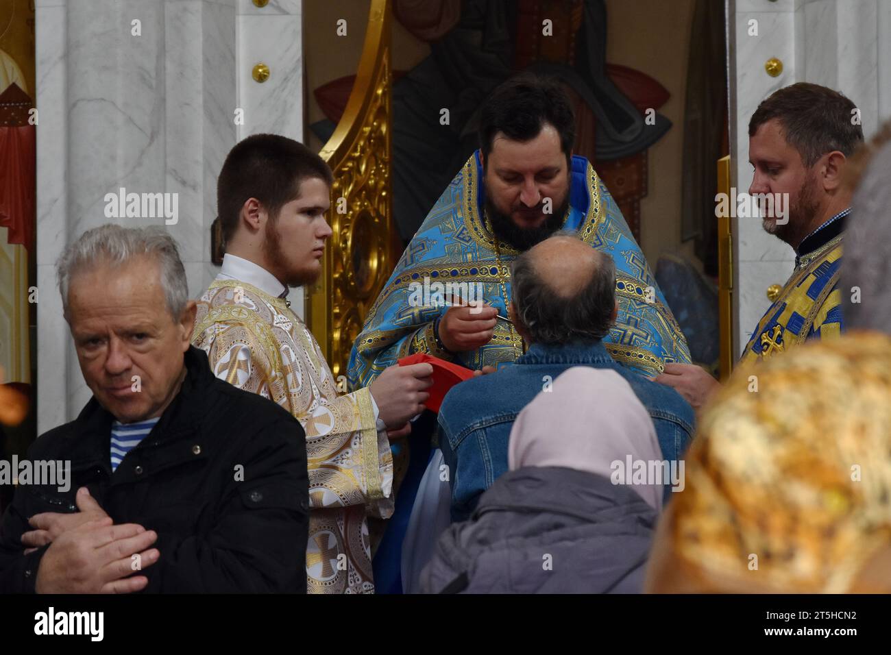 Orthodoxe christliche Priester und Gläubige werden während der Eucharistiefeier nach dem Gottesdienst in der Kirche der Heiligen Gleichgesinnten Olga in Zaporischschschiha gesehen. Der 4. November ist der Festtag der kasanischen Ikone der Mutter Gottes. Die kasanische Ikone der Mutter Gottes ist eine verehrte wundersame Ikone der Mutter Gottes, die 1579 in Kasan (Russland) erschien. Eine der verehrtesten Ikonen der Russisch-Orthodoxen Kirche. Die kasanische Ikone der Mutter Gottes wird für spirituelle Erleuchtung gebetet, einschließlich der Suche nach den Rechten Stockfoto